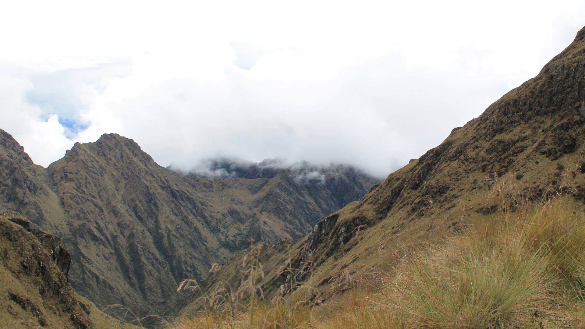 Rugged Andean mountainside with clouds, representing the challenging high-altitude terrain of the Classic Inca Trail 4 Days - Aremika Travel