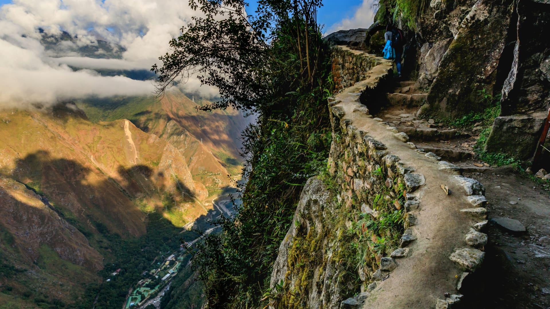 Ancient stone path of the Classic Inca Trail 4 Days carved into a mountainside with vast valley views, highlighting the trek to Machu Picchu - Aremika Travel