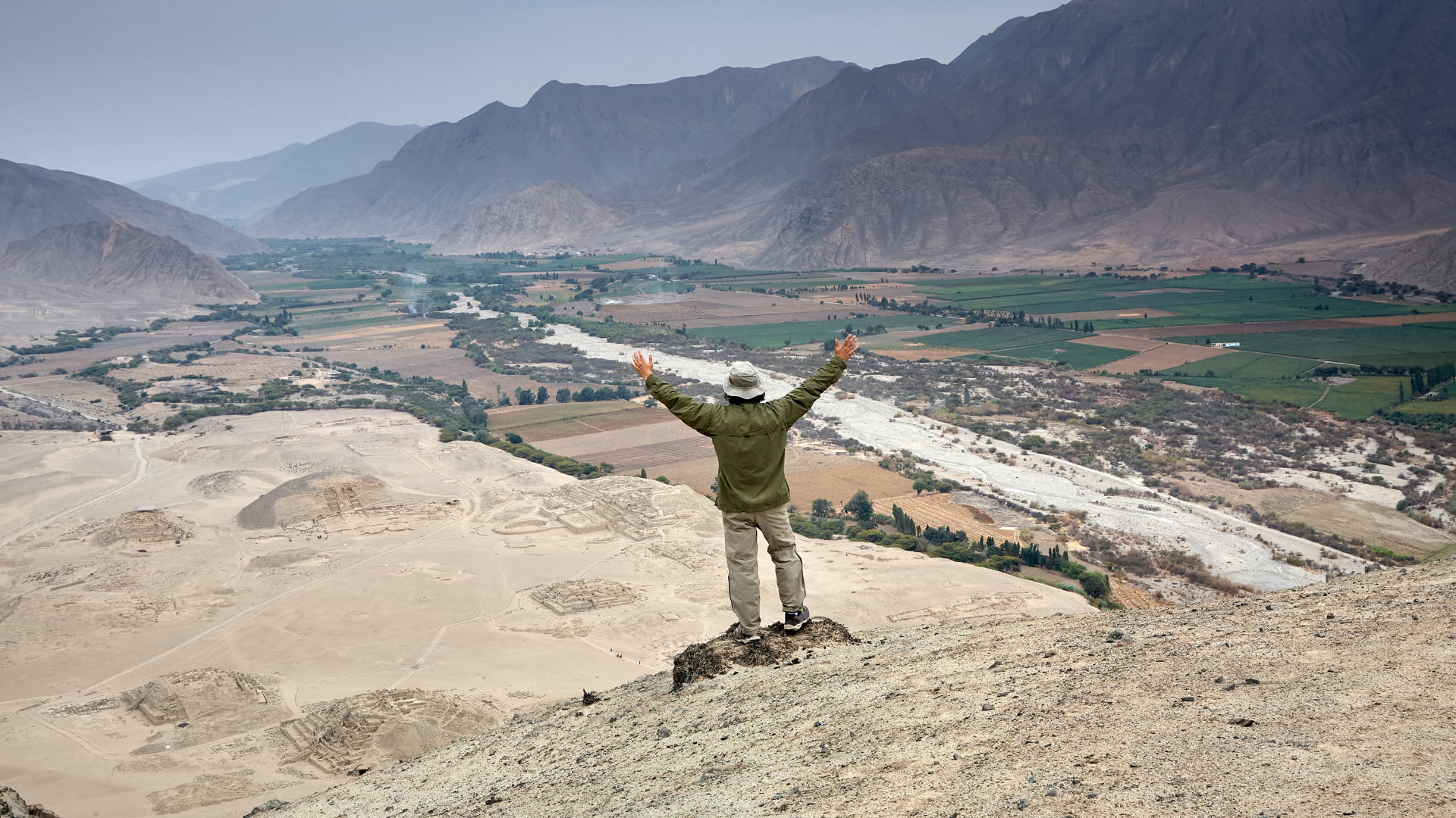 A traveler overlooking the vast archaeological site on the Tour to Caral from Lima, the oldest city in the Americas - Aremika Travel